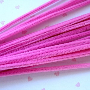 Puede incluir: Un paquete de limpiapipas rosas, tambi&eacute;n conocidos como tallos de chenilla, est&aacute;n dispuestos en forma de abanico. Los limpiapipas son suaves y peludos, y son perfectos para manualidades.