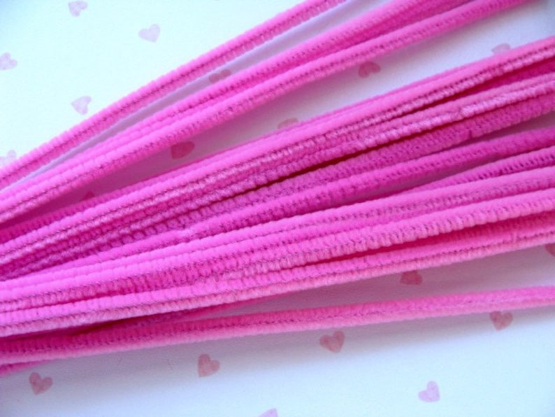 Puede incluir: Un paquete de limpiapipas rosas, tambi&eacute;n conocidos como tallos de chenilla, est&aacute;n dispuestos en forma de abanico. Los limpiapipas son suaves y peludos, y son perfectos para manualidades.
