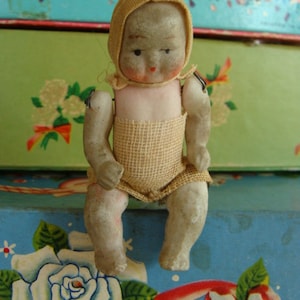 One Antique Jointed Bisque Baby Doll with  Bonnet and Clothes