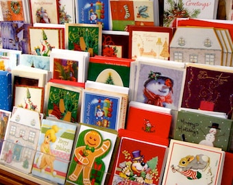 Könnte beinhalten: Eine Auswahl an Weihnachtsgrußkarten mit festlichen Designs. Die Karten zeigen Illustrationen von Schneemännern, Lebkuchenmännern und Urlaubsszenen. Die Farbpalette umfasst Rot, Grün, Blau und Weiß. Einige Karten haben Texte wie "Frohe Feiertage" und "Frohe Weihnachten".