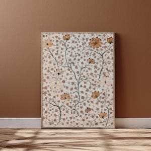 May include: A framed floral print featuring a cream-colored background with a repeating pattern of small brown leaves. The print showcases stylized flowers in shades of orange and cream, with dark brown stems and branches.