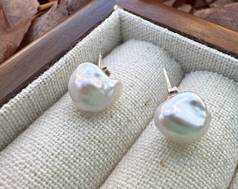 Può includere: Un paio di orecchini con perle barocche bianche e perni in argento, esposti in una piccola scatola di legno con fodera in tessuto bianco.