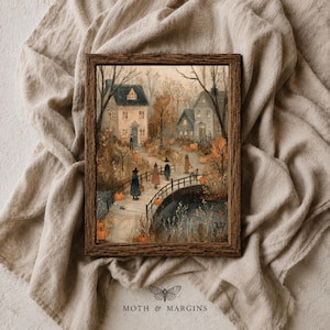 May include: A framed wall art print depicting a fall scene with houses, a bridge, and figures wearing pointed hats. The landscape features orange pumpkins, bare trees, and muted earth tones. The text MOTH & MARGINS appears at the bottom.