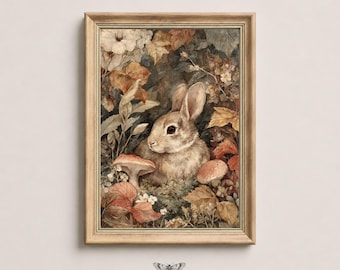 May include: A framed wall art print featuring a brown rabbit surrounded by autumn leaves, foliage, and mushrooms in muted earth tones. The artwork is encased in a light wood frame. Below the frame, the text reads MOTH & MARGINS.