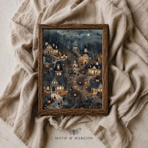 May include: A framed rectangular wall art print featuring a dark, atmospheric village scene at night with glowing orange pumpkins, illuminated houses, bare trees, and silhouettes of birds against a moonlit sky. The text MOTH & MARGINS is visible.