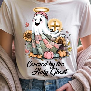 A white t-shirt with a cozy and uplifting holy ghost design, accented by soft autumn hues and a heartfelt message. Clean and crisp, the design shines with warmth and clarity on light fabric — perfect for subtle, faith-filled looks.