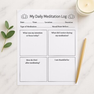 May include: A white "My Daily Meditation Log" sheet with prompts for daily reflection. Includes sections for date, time, and intention, with a gold pen and lit candle in the background. A sprig of green leaves is on the left.