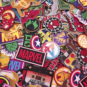Pode incluir: Uma coleção de patches bordados coloridos com vários personagens e logotipos da Marvel Comics. Os patches incluem Homem-Aranha, Capitão América, Homem de Ferro e o logotipo da Marvel. Os patches são de várias formas e tamanhos.