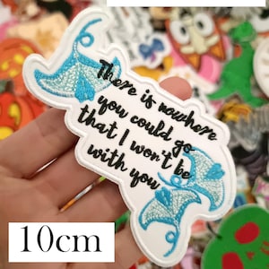 May include: A white embroidered patch with the text "There is nowhere you could go that I won't be with you" and two blue manta ray designs. The patch is 10cm in length and features the words "Moana Quote".