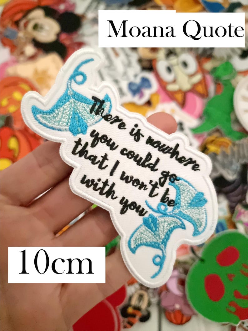 K&ouml;nnte beinhalten: Ein wei&szlig;er, gestickter Aufn&auml;her mit dem Zitat "There is nowhere you could go that I won't be with you" und zwei blauen Mantarochen-Designs. Der Aufn&auml;her ist 10 cm lang und tr&auml;gt oben die Worte "Moana Quote".