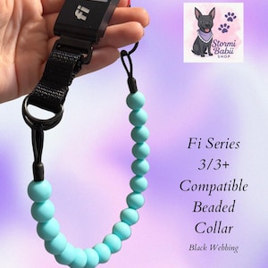 May include: Black Fi Series 3/3+ compatible beaded dog collar with light blue beads and black webbing. The collar has a black Fi Series tracker attached. The image also includes a logo with a dog and the text "Stormi Babii Shop".