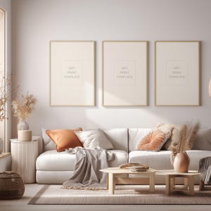 Puede incluir: Un salón moderno con un sofá blanco, cojines decorativos y tres impresiones artísticas enmarcadas en la pared. La habitación presenta una paleta de colores neutros con detalles en madera, una mesa de centro y una alfombra.