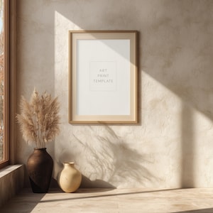 Puede incluir: Una plantilla de impresión artística enmarcada con el texto "ART PRINT TEMPLATE" se muestra en una pared texturizada. Un jarrón marrón con plantas secas y un jarrón beige se encuentran sobre una superficie embaldosada. La habitación está iluminada por luz natural.
