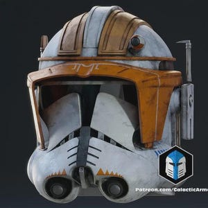 Könnte beinhalten: Ein detaillierter, verwitterter Helm in Weiß, Orange und Grau, mit einem Design, das an einen Weltraumtruppler erinnert. Der Helm hat ein Visier, Ohrenteile und ein Kommunikationsgerät. Der Text "Patreon.com/GalacticArmory" ist sichtbar.