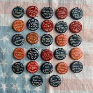 Puede incluir: Una colección de botones de solapa vintage con varias frases en texto blanco sobre fondos rojos y azules. Los botones presentan frases como "I'm the guy that put the cats in the Catskills" y "I'm the guy that put the hands on the clock."
