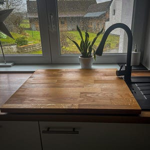 Może przedstawiać: Biały ceramiczny kubek z czarnym uchwytem i napisem "But First, Coffee" czarną, pogrubioną czcionką. Kubek stoi na białej powierzchni. Kubek ma pojemność około 355 ml.