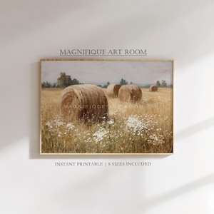 Op de afbeelding: Een ingelijste landschapsafdruk met hooibalen in een gouden veld met witte wilde bloemen. De print heeft een vintage esthetiek, met de tekst "MAGNIFIQUE ART ROOM" en "INSTANT PRINTABLE | 8 SIZES INCLUDED".