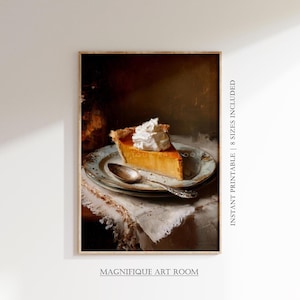 May include: A framed print of a slice of pumpkin pie topped with whipped cream on a decorative plate with a spoon. The plate rests on a white cloth. The words "INSTANT PRINTABLE | 8 SIZES INCLUDED" and "MAGNIFIQUE ART ROOM" are printed on the image.