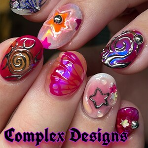 May include: Close-up of a hand with elaborately designed nail art. Each nail features a unique design, including stars, swirls, and butterfly patterns, with 3D elements and metallic accents. The text "Complex Designs With 3D" is displayed at the bottom.