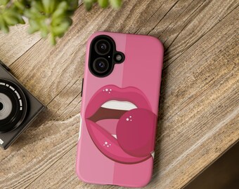 Puede incluir: Una funda de smartphone rosa con una ilustración gráfica de labios de color rosa brillante con dientes blancos y una piruleta redonda rosa. La funda tiene un fondo rosa de dos tonos con una línea vertical que separa los tonos en la parte trasera.