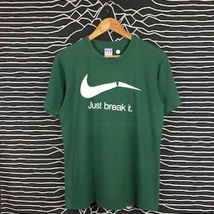 May include: Green t-shirt with a white Nike swoosh and the text "Just break it."