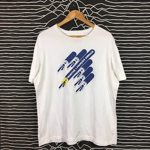 May include: White t-shirt with a blue and yellow graphic print of the text "MARITHÉ + FRANÇOIS GIRBAUD".