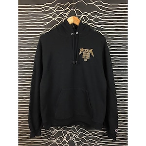 May include: Black hoodie with a front pocket and a drawstring hood. The gold text on the front reads "YEEZY" above "KANYE WEST GLASTONBURY SAT. JUNE 27 2015". The hoodie has the Champion logo on the left sleeve.