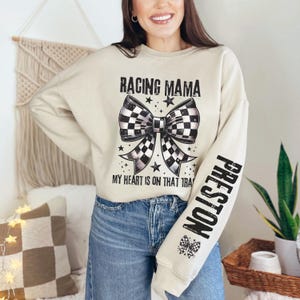 May include: A beige sweatshirt with a black and white checkered bow and the text "Racing Mama" and "My heart is on that track". The right sleeve has the text "Preston" in black.