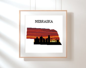 May include: A framed print of the state of Nebraska with a sunset over the city skyline. The text "NEBRASKA" is at the top of the print.