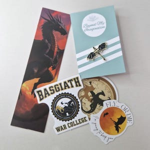 May include: A set of dragon-themed items including a bookmark with a black dragon, a sticker with a black dragon and the text "Basgiath War College", a sticker with a black dragon and the text "Fly... Or Die. I'm going to beep you", and a pin with a black dragon.
