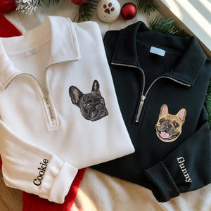 Peut inclure: Un sweat-shirt blanc à fermeture éclair avec un bouledogue français noir brodé et le nom Cookie sur la manche, à côté d'un sweat-shirt noir avec un bouledogue français fauve brodé et le nom Gunny sur la manche.