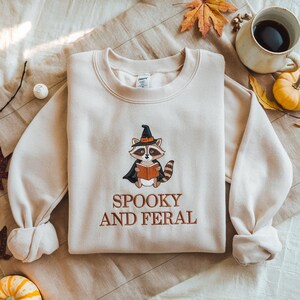 Embroidered Retro Spooky And Feral Raccoon Sweatshirt, Halloween Raccoon Reading Book Shirt, Cute Raccoon Ghost Hoodie, Halloween Mama Shirt