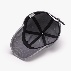 Puede incluir: Gorra de b&eacute;isbol gris, vista desde el interior, con visera curva. La gorra presenta un dise&ntilde;o de seis paneles con forro interior negro y una correa de tela ajustable. La gorra tiene un aspecto descolorido y desgastado.