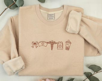 Moletom bordado com ícone de enfermeira: Coquette Healthcare Apparel