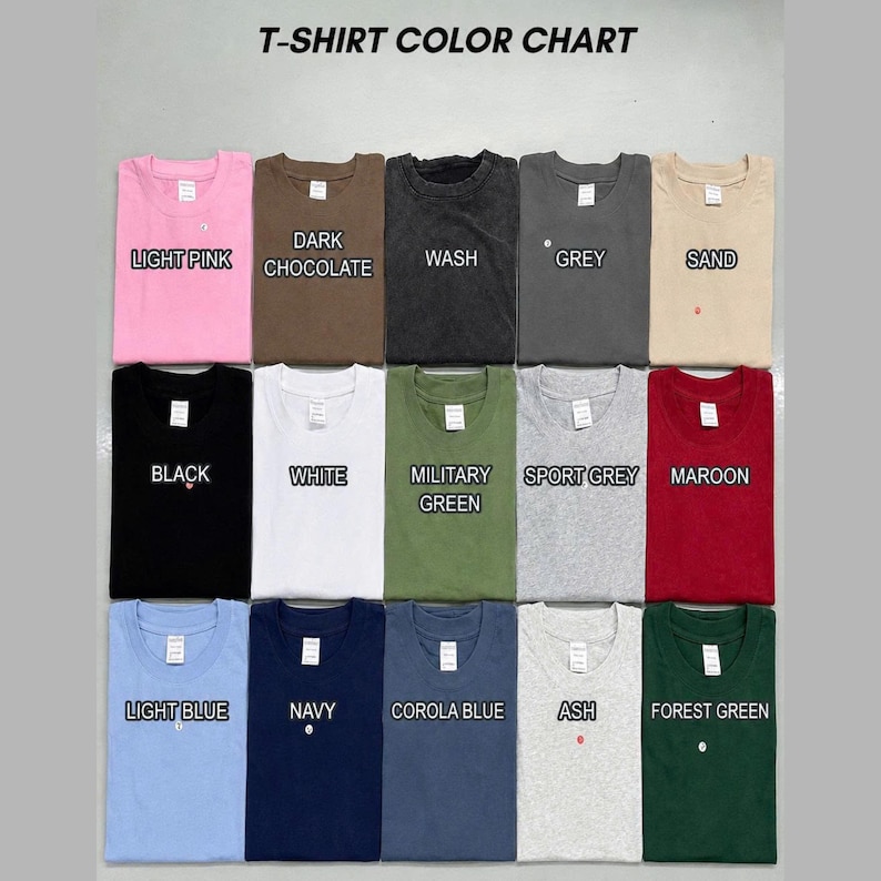 May include: A T-shirt color chart displaying fifteen folded crew neck shirts in various colors including light pink, dark chocolate, wash, grey, sand, black, white, military green, sport grey, maroon, light blue, navy, corola blue, ash, and forest green.