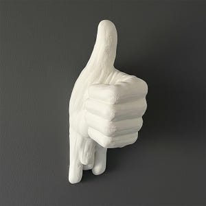 Può includere: Una scultura da parete bianca a forma di mano che fa il gesto del pollice in su. La superficie dell'oggetto presenta strati orizzontali visibili e una finitura testurizzata, che mostra le linee distinte create dal processo di produzione additiva.
