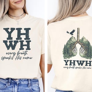May include: A beige t-shirt with the text "YHWY every breath speaks His name" on the front and a graphic of a pair of lungs with roots and a bird flying above on the back.