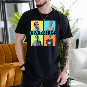 May include: Black t-shirt with the text "DAD VIBES" and four square images of men. The squares are in yellow, blue, green, and orange. The t-shirt is made of a soft material.