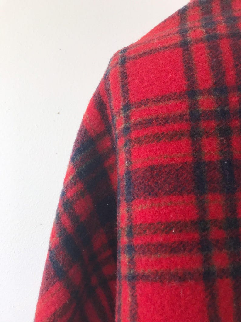 May include: Red, black, and green plaid fabric with a fuzzy texture.