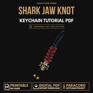 May include: A digital PDF tutorial for a shark jaw knot keychain. The image features a paracord keychain with a black and dark red braided pattern, a brass-colored samurai helmet bead, and two brass-colored end caps on black cord ends.