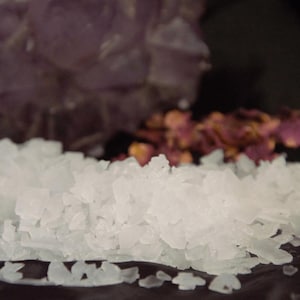 May include: Close-up of white, coarse sea salt crystals. The salt is piled high and appears to be very fine-grained.