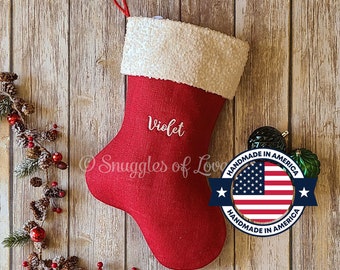 Puede incluir: Un calcetín navideño rojo con puño blanco y lazo rojo para colgar. El nombre "Violet" está bordado en la parte delantera. Hecho a mano en Estados Unidos.