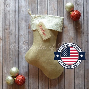 Op de afbeelding: Een kerstsok van jute met een witte nep bontkraag en een gepersonaliseerd label met de tekst "Watson". De sok is versierd met een rood, wit en blauw "Handmade in America" label.