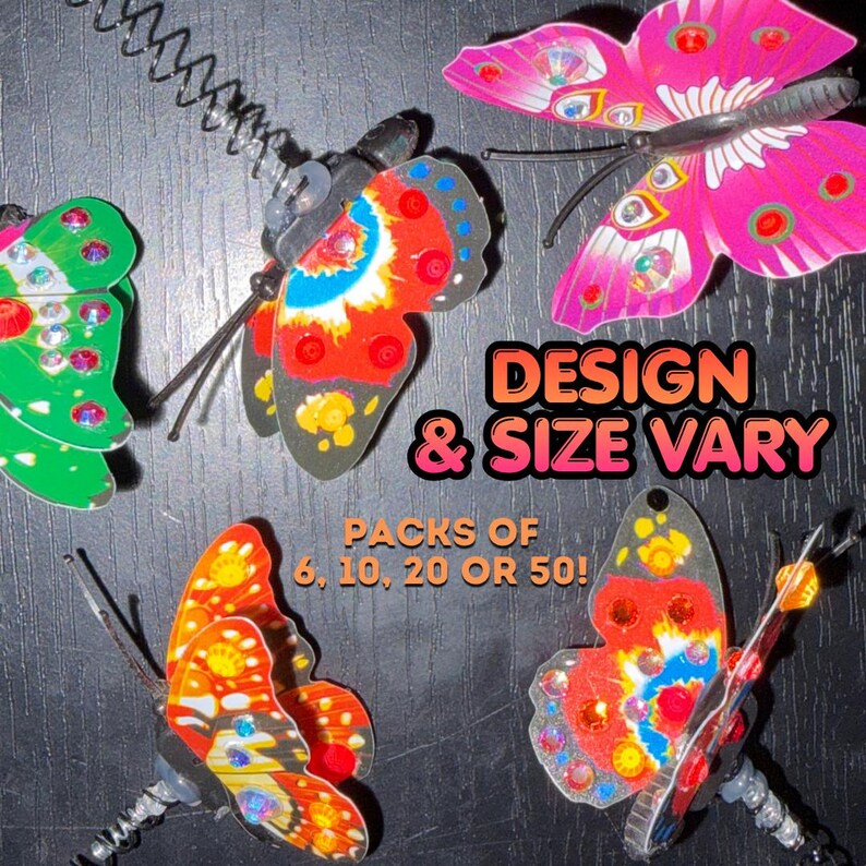 Op de afbeelding: Vier decoratieve vlinderornamenten op metalen veren, met levendige roze, groene, oranje en rode patronen en strass-steentjes. De tekst op de afbeelding luidt: DESIGN & SIZE VARY, PACKS OF 6, 10, 20 OR 50!