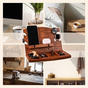 May include: A wooden desk organizer with multiple compartments for a phone, watch, keys, and other accessories. The organizer is stained a dark brown color and has a sleek, modern design. A cup of coffee, a plant, and a sleep mask are also visible.