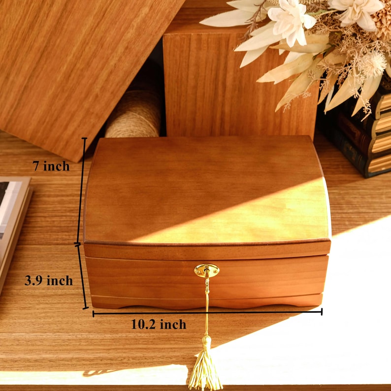 May include: A wooden jewelry box with a gold lock and tassel. The box measures 10.2 inches wide, 3.9 inches deep, and 7 inches tall.