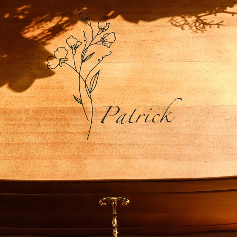 May include: A wooden box with a floral design and the name "Patrick" engraved on the lid. The box has a gold latch and a chain.