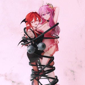 May include: A clear acrylic figure featuring two anime-style female characters. One has red hair and black attire, the other has pink hair and a pink outfit. They are wrapped in black cords and stand on a clear base.