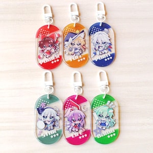 May include: Six oval acrylic keychains featuring chibi anime characters. Each keychain has a silver lobster clasp and a unique color background: red with text POWER, orange with FULL, blue with POINT, teal with STAR, pink with LIFE, and green with BOMB.