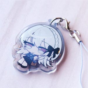 May include: A clear acrylic charm featuring a chibi-style illustration of a character with white hair, a black hair bow, and a blue school uniform. The charm is attached to a silver-toned metal lobster clasp and a thin, light blue cord strap.